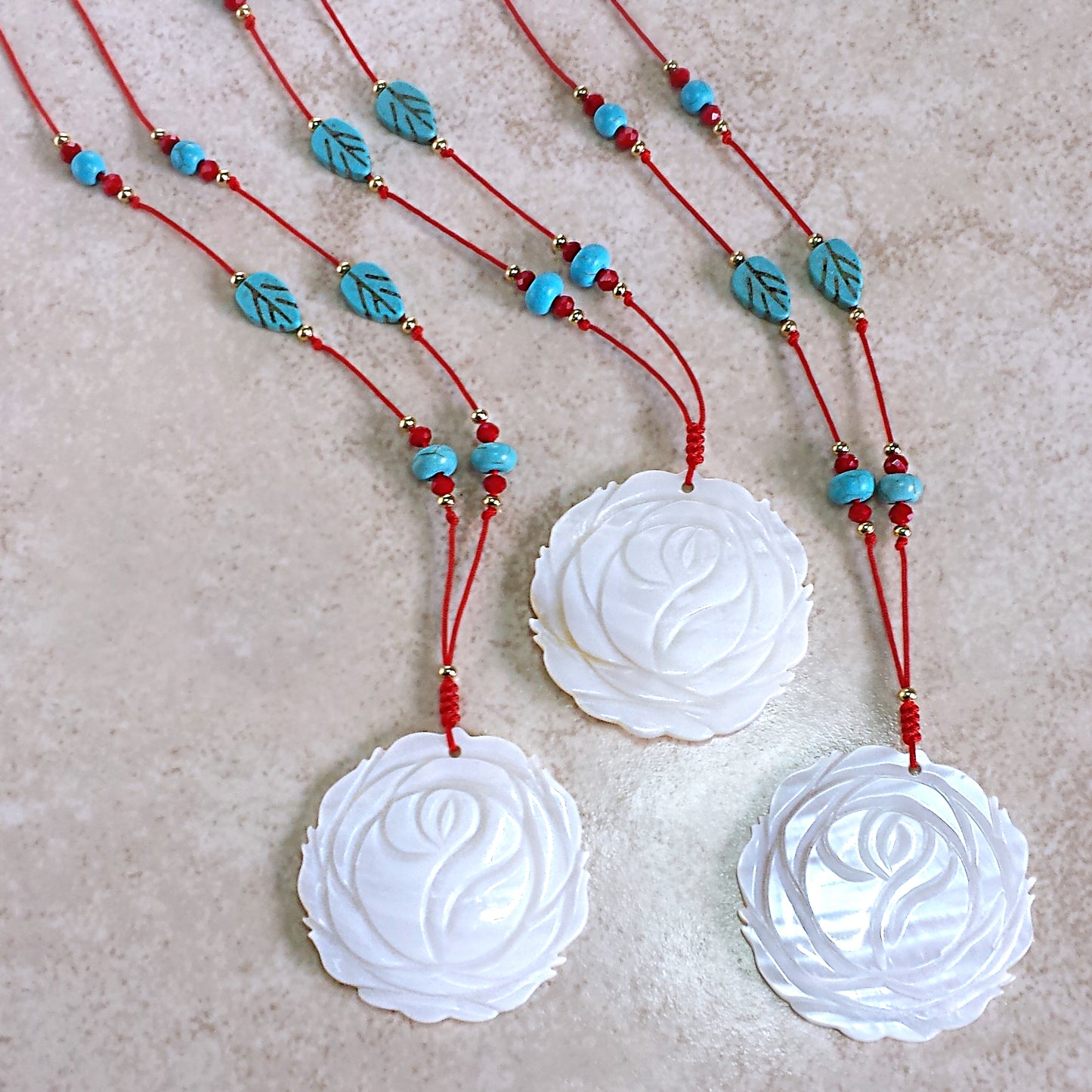 White mother of pearl focal point pendant red string necklace with red, gold and turquoise accents.