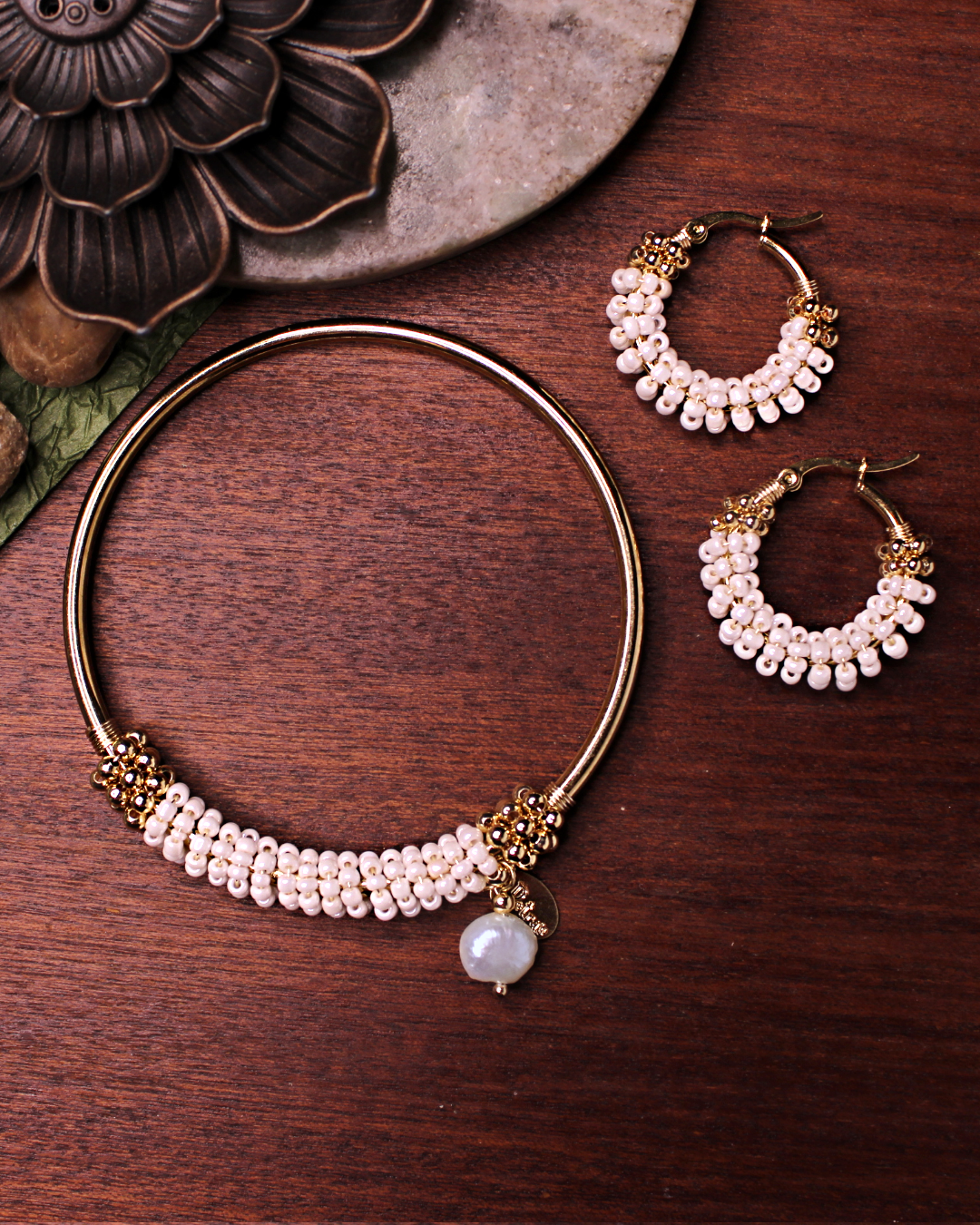 Small stainless steel gold colored hoop earrings with bone white seed beads. Matching stainless steel gold bracelet.