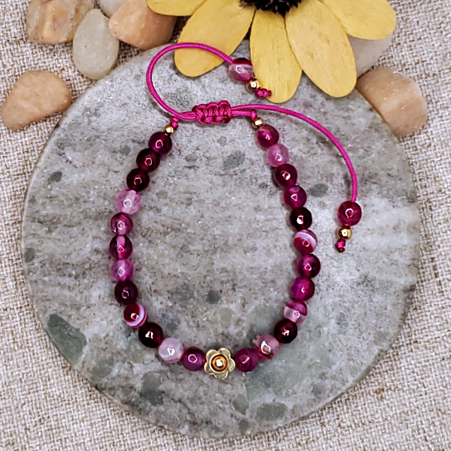 Pink faceted bead bracelet with gold flower bead. Adjustable bracelet.