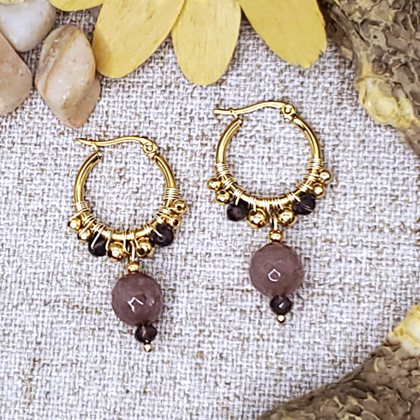 Small gold dangling hoop earrings with faceted mauve jade bead.