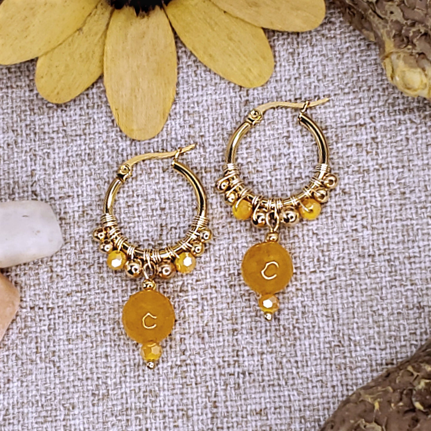 Small gold dangling hoop earrings with faceted yellow jade bead.