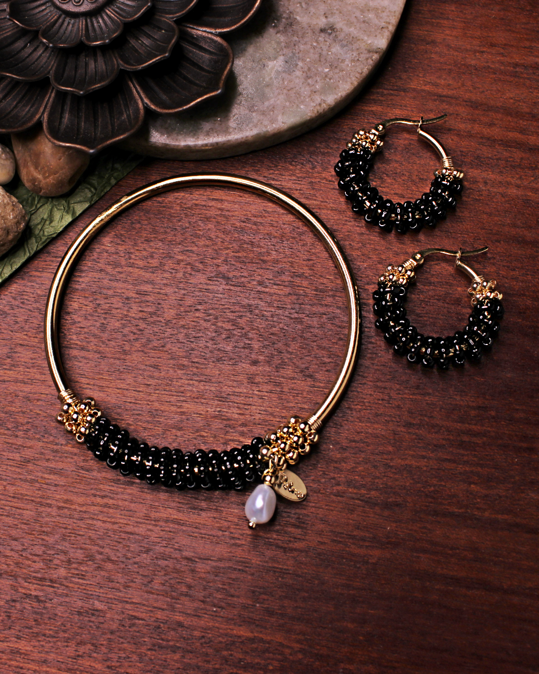 Small stainless steel gold colored hoop earrings with black crystal seed beads. Matching stainless steel gold bracelet. 