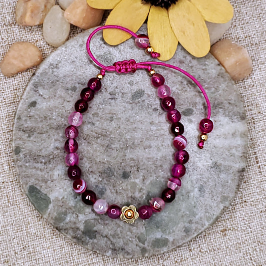 Pink faceted bead bracelet with gold flower bead. Adjustable bracelet.