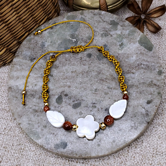 White mother of pearl flower and leaves bead bracelet, with sandstone beads accents. Adjustable gold cord macrame bracelet. 