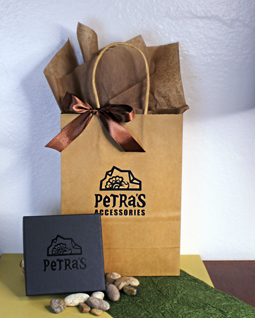 Jewelry giftwrap. Black jewelry box with PeTRa'S ACCESSORIES logo. Brown kraft bag with PeTRa'S ACCESSORIES logo. Brown satin bow and brown tissue paper. 