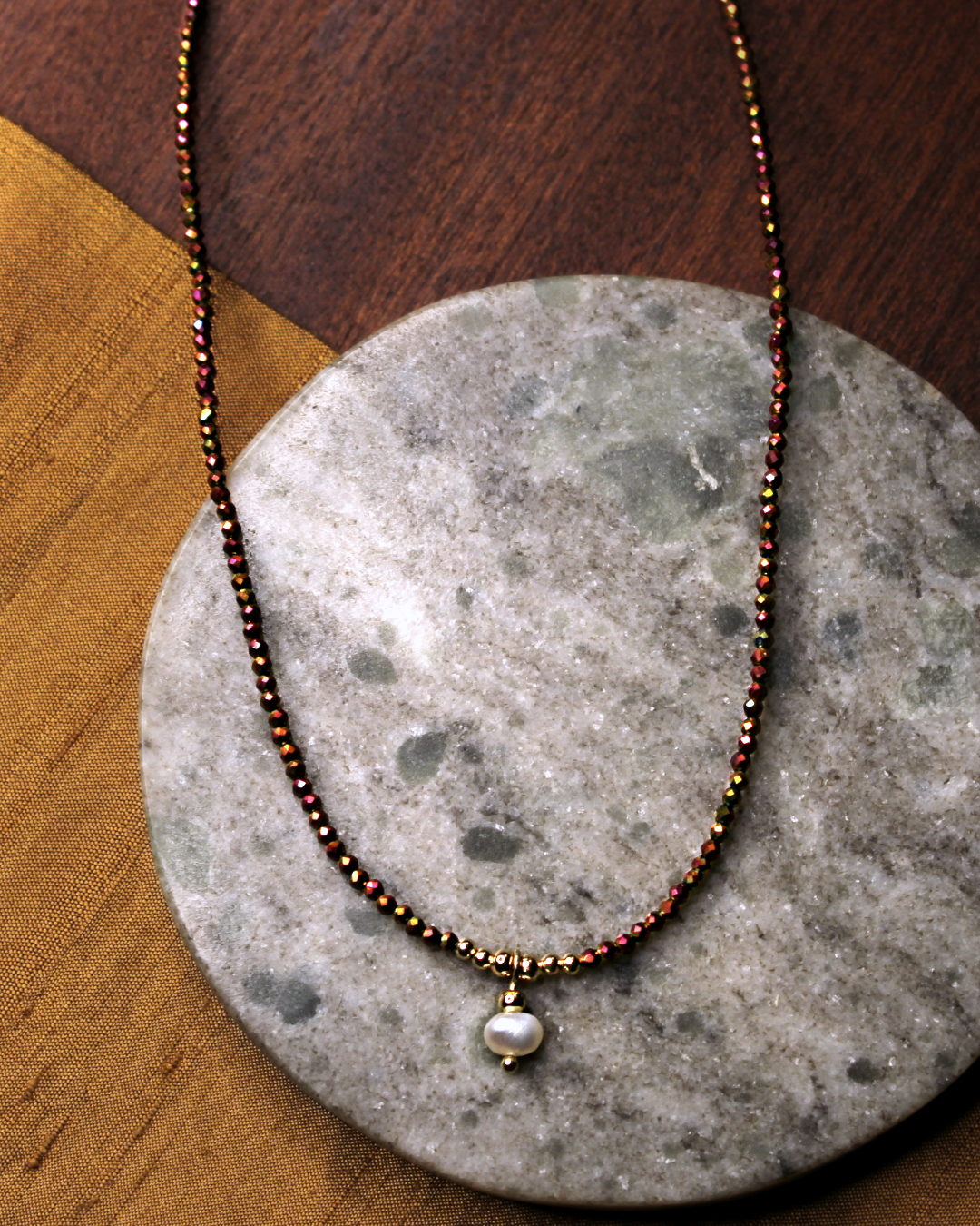 Dainty necklace with small faceted copper color crystal beads and dangling freshwater pearl charm.