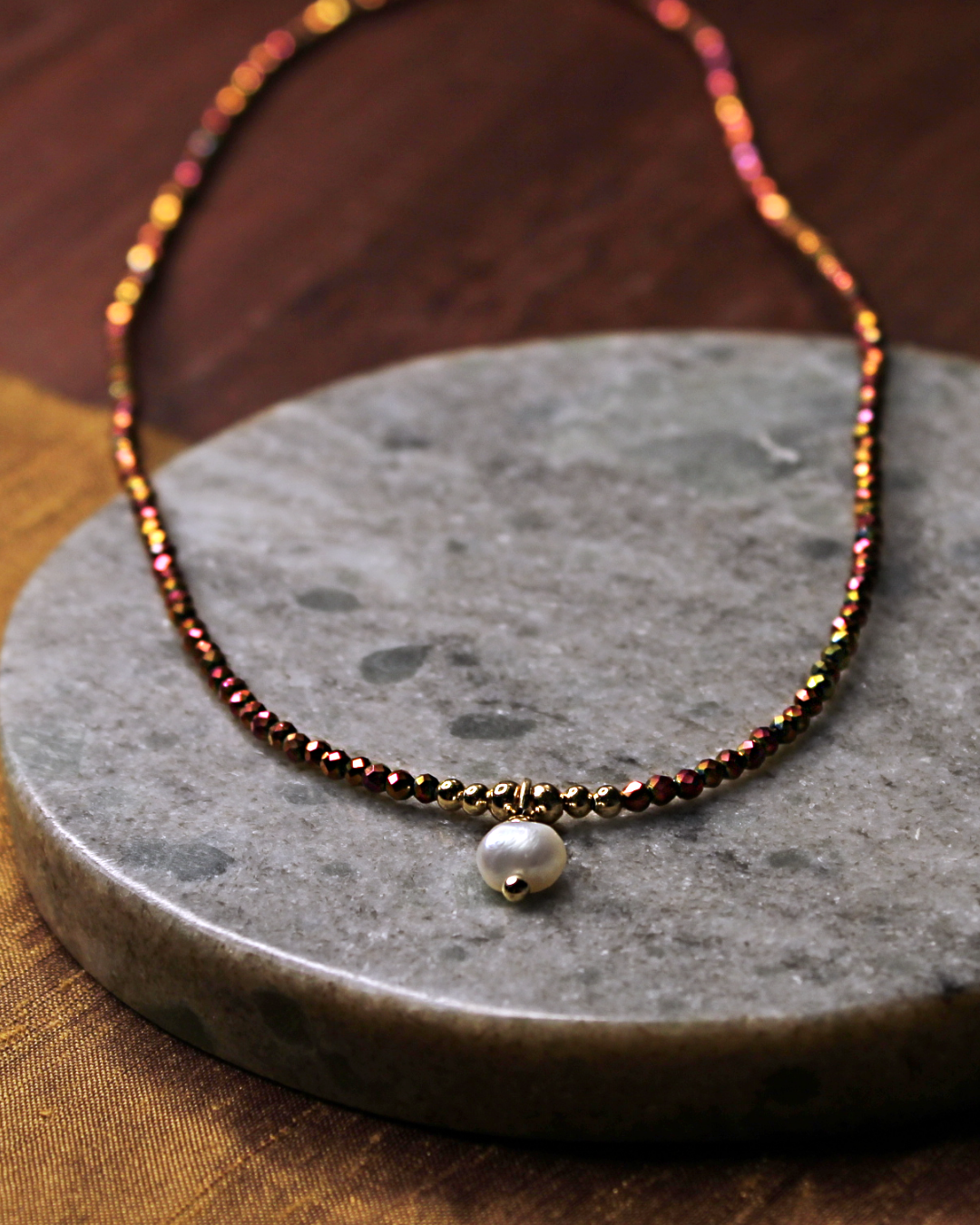Dainty necklace with small faceted copper color crystal beads and dangling freshwater pearl charm.